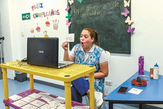 A teacher explains phonemes to a group of children at their homes during a virtual class from the Chiquilandia Kindergarten, amid the COVID-19 novel coronavirus pandemic, in Medellin, Colombia, on September 3, 2020. Kindergartens in Colombia were allowed to reopen in a gradual way since September 1 and they are operating under a combined model - attending school on-site and taking classes online. / AFP / Joaquin SARMIENTO
