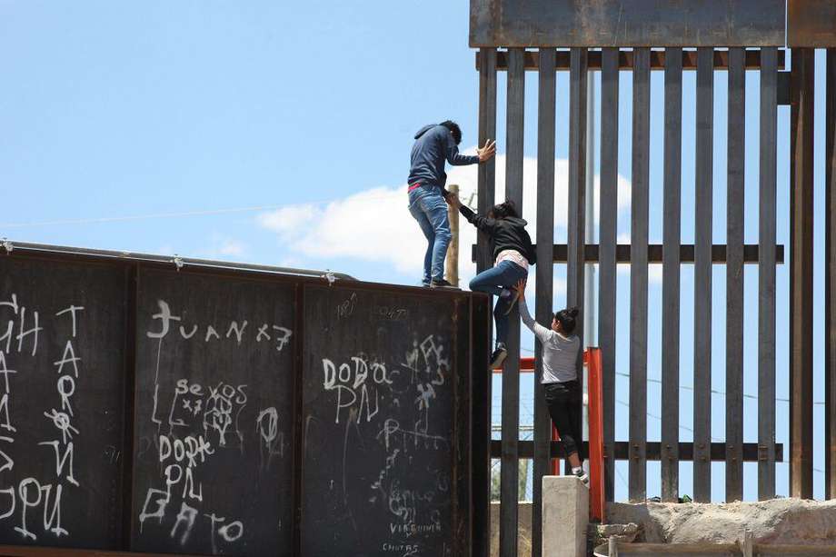 Un grupo de personas tratan de saltar el muro para entrar a territorio estadounidense. desde el puente negro, en la línea fronteriza de Ciudad Juárez, en el estado de Chihuahua (México). / EFE