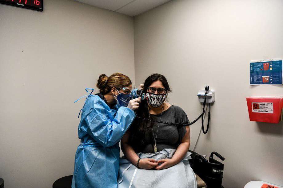 La doctora Nelia Sanchez-Crespo (izquierda) examina a Heather Lieberman, de 28 años, mientras participa en un estudio de vacunación contra COVID-19 en los Centros de Investigación en Hollywood (EEUU). CHANDAN KHANNA / AFP.