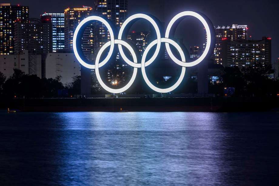 This long exposure picture shows the lit Olympic rings at the waterfront of Odaiba in Tokyo on December 1, 2020. (Photo by Philip FONG / AFP)