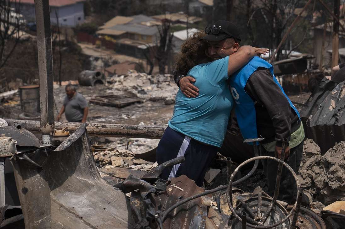 AME5705. VIÑA DEL MAR (CHILE), 04/02/2024.- Personas se abrazan en una casa en el sector de Achupallas afectada por incendios forestales de Viña del Mar, Región de Valparaiso (Chile). Las autoridades chilenas informaron este domingo de que el número de muertos en los devastadores incendios que han consumido grandes sectores de viviendas en la región de Valparaíso, a 100 kilómetros al este de Santiago, aumentó a 56, aunque se espera que siga creciendo con las horas. EFE/ Adriana Thomasa