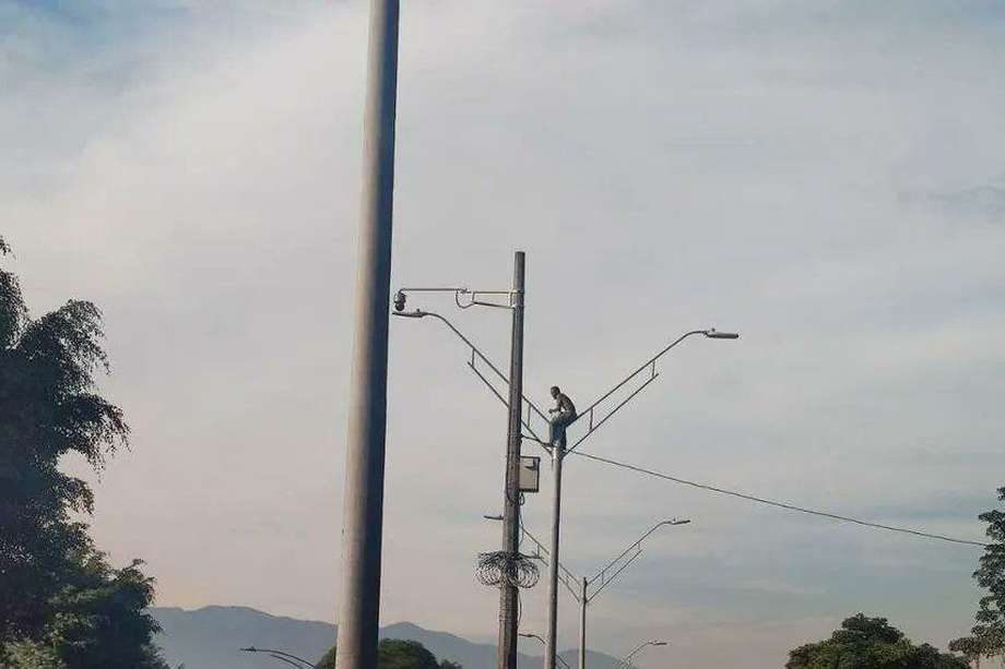 En las imágenes captadas por varios testigos del hecho, se puede ver como el hombre logró subir por el poste, a un costado de la Autopista Norte, en Medellín.