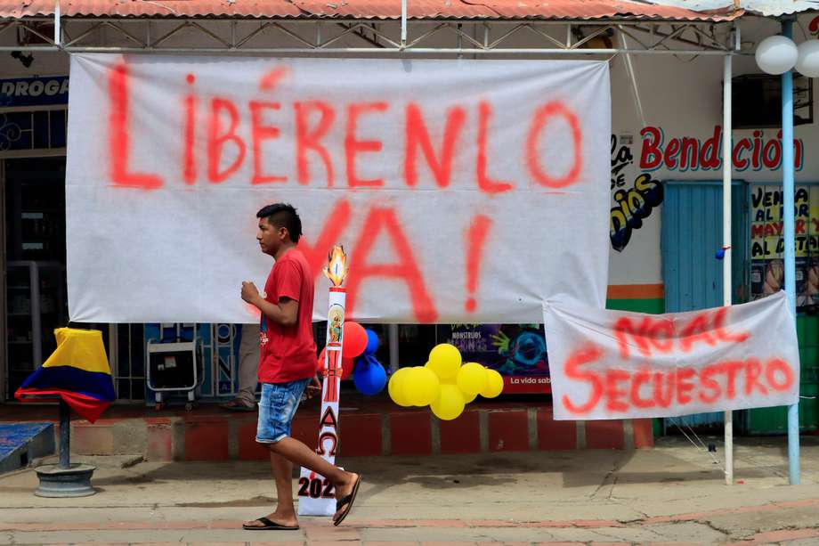 Un hombre camina frente a carteles que rechazan el secuestro de Luis Manuel Díaz, padre del delantero de la selección colombiana de fútbol y del club inglés Liverpool, Luis Díaz.