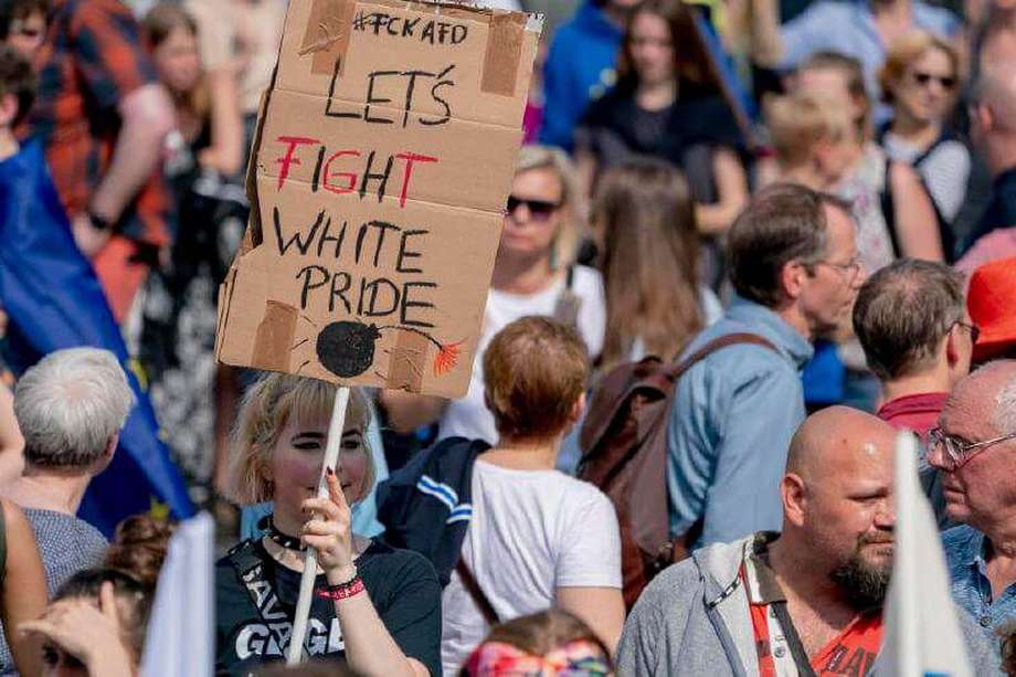 Una mujer alemana sostiene  una pancarta con la frase: “Luchemos por el orgullo blanco” durante una protesta. / EFE