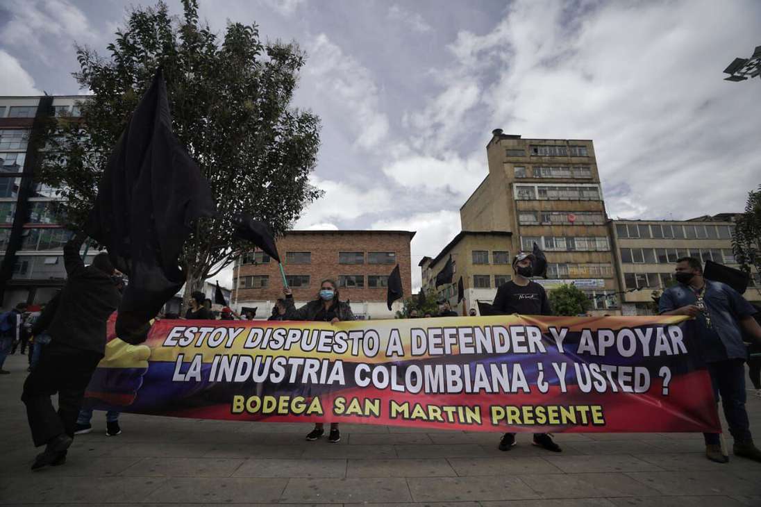 Personas sostienen una pancarta en la que se lee: estoy dispuesto a defender y apoyar la industria colombiana ¿y usted?