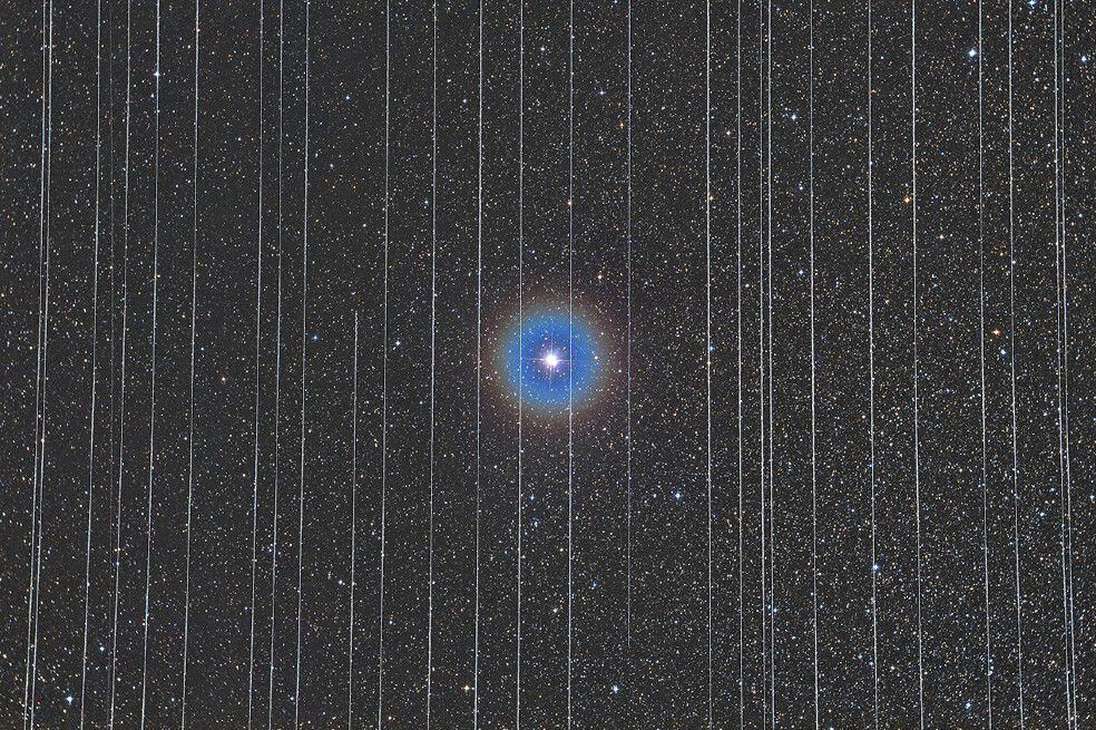 Categoría gente y espacio: la estrella en el centro de la imagen es la estrella doble Albireo, rodeada por los rastros de satélites en movimiento.