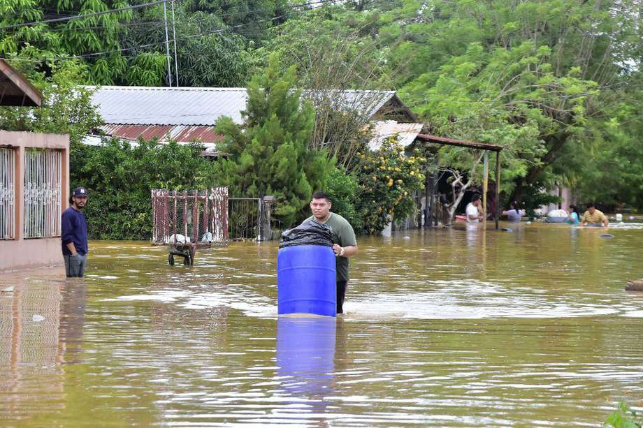 Personas intentan salvar hoy sus pertenencias mientras abandonan sus viviendas, inundadas debido a las fuertes lluvias en la comunidad de Palermo, en El Progreso, departamento de Yoro (Honduras).