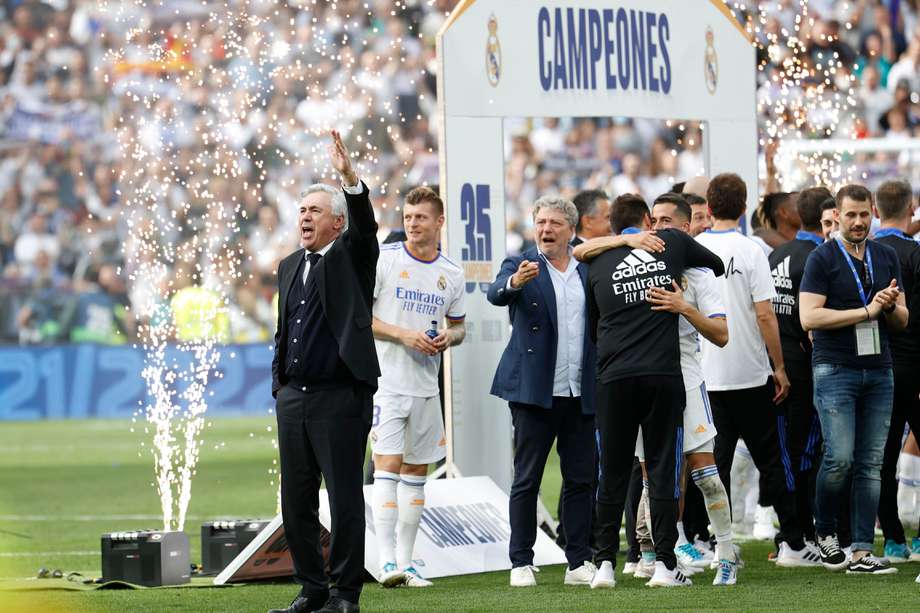 El entrenador del Real Madrid Carlo Ancelotti celebra el título de Liga conseguido por los jugadores tras vencer al Espanyol este sábado en el estadio Santiago Bernabéu, en Madrid. 

