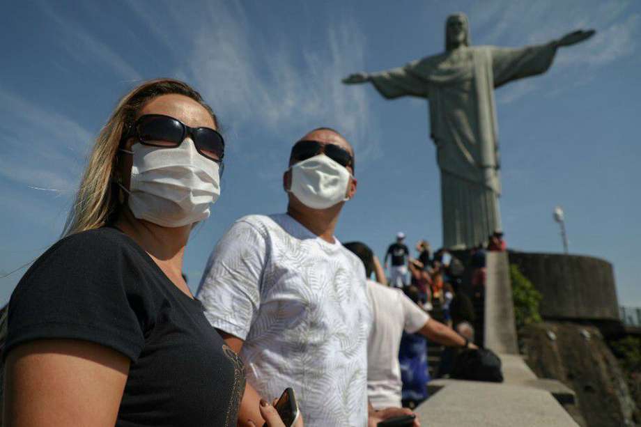 Los turistas disfrutan de una visita a la estatua del Cristo Redentor, en el Cerro Corcovado, en Río de Janeiro, Brasil, el 15 de agosto de 2020, durante el día de reapertura de las atracciones turísticas de la ciudad en medio de la pandemia del nuevo coronavirus COVID-19.