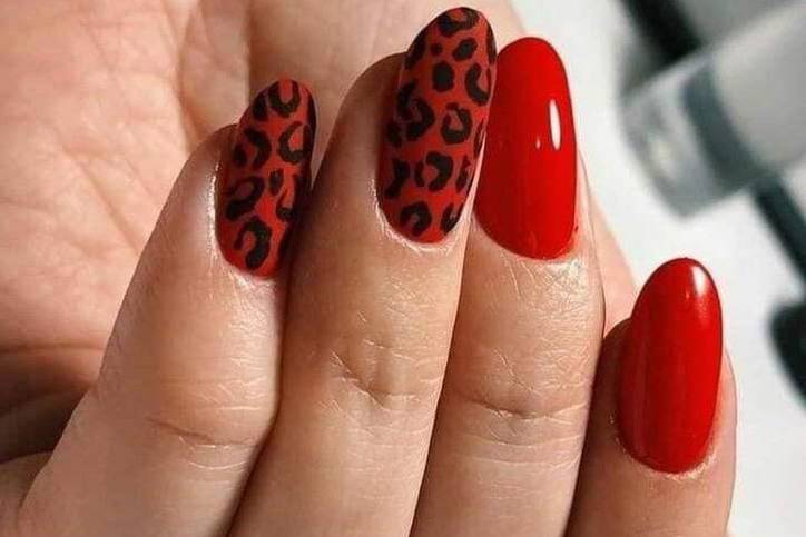 Este diseño es audaz y moderno. Necesitarás esmalte de uñas rojo, esmalte de uñas negro y un pincel delgado. Pinta tus uñas de rojo y deja que se sequen. Luego, con el pincel delgado y el esmalte negro, dibuja pequeñas manchas de leopardo en tus uñas. No te preocupes si no son perfectas, el estampado de leopardo se ve mejor cuando es un poco irregular.