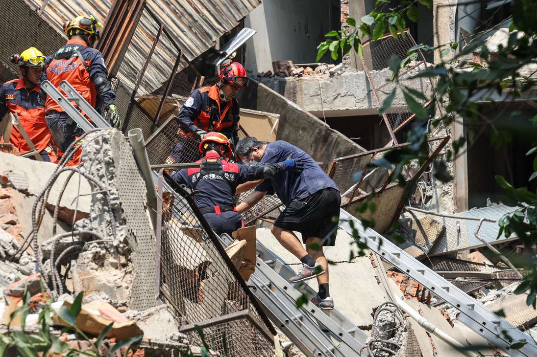 Esta foto tomada por la Agencia Central de Noticias de Taiwán (CNA) el 3 de abril de 2024 muestra a los trabajadores de emergencia ayudando a un sobreviviente después de que fue rescatado de un edificio dañado en la ciudad de Nuevo Taipei, después de que un gran terremoto azotara el este de Taiwán.
