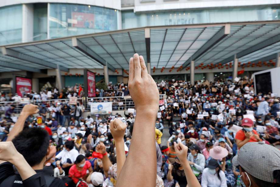 Manifestantes realizan el símbolo de la resistencia con la mano durante una protesta en contra del golpe de estado.