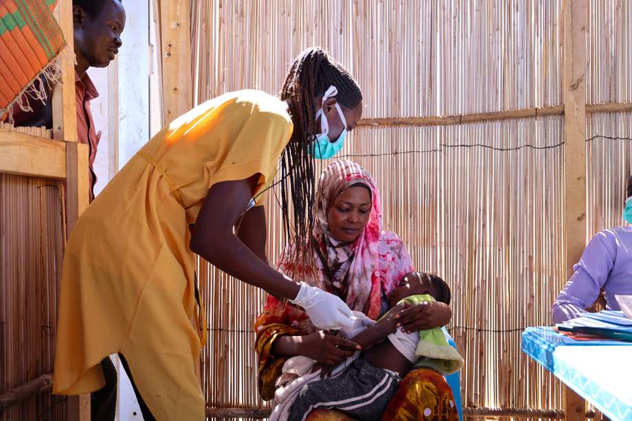 Halima Abdurahman Dawud sostiene a su hija Aszed Mohammed, que está recibiendo una vacuna en el sitio de distribución de Médicos Sin Fronteras en Renk, Alto Nilo. Halima es una refugiada de Sudán que llegó a Renk buscando seguridad.