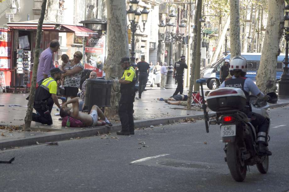 Efectivos policiales atienden a una de las víctimas del atropello masivo en La Rambla de Barcelona. / EFE
