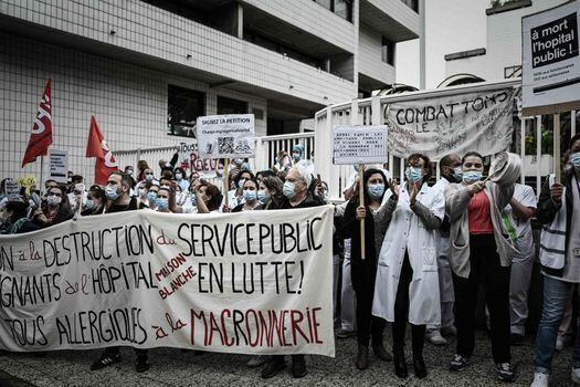 Un grupo de trabajadores de un hospital de París protestan contra el presidente francés, Emmanuel Macron.