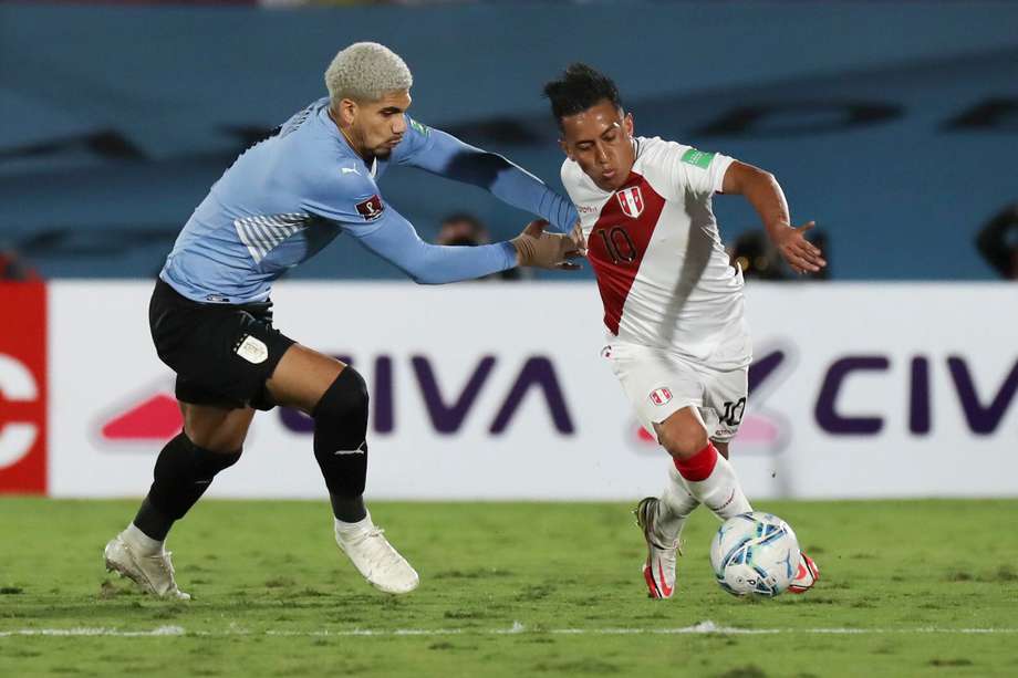 Ronald Araújo (i) de Uruguay disputa el balón con Christian Cueva de Perú durante un partido por las eliminatorias sudamericanas al Mundial de la FIFA Catar 2022.