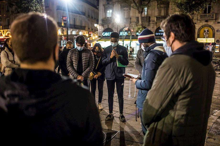 Un grupo de personas rezan por las víctimas del ataque terrorista en Niza, momentos antes de entrar a un nuevo confinamiento por coronavirus.