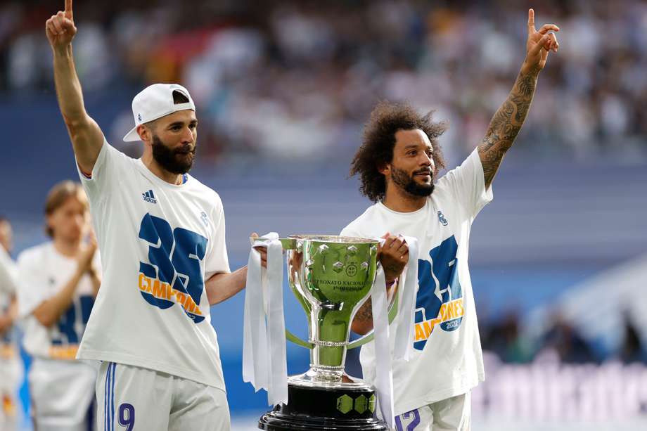 Los jugadores del Real Madrid Karim Benzemá (i) y Marcelo Vieira celebran el título de Liga, al término del partido de Liga en Primera División ante el RCD Espanyol que han disputado este sábado en el estadio Santiago Bernabéu, en Madrid.

