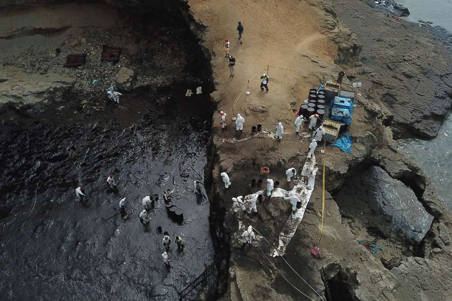 Vista aérea de brigadas de limpieza ayudando a recoger el crudo de una playa al norte de Lima.