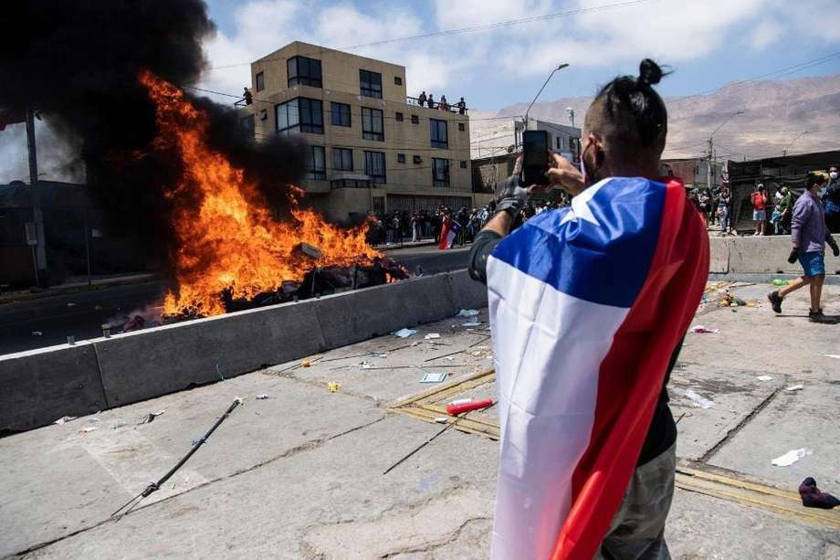 Un campamento improvisado de migrantes venezolanos arde después de ser incendiado por manifestantes chilenos anti-migración.