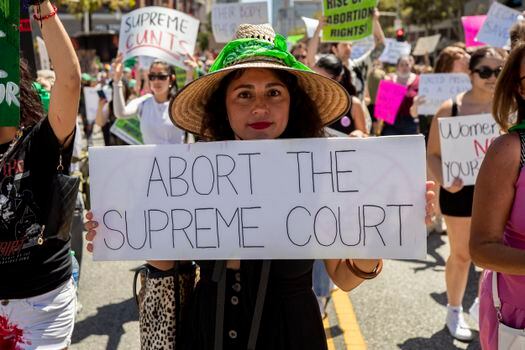 An abortion rights protester holds a sign that reads 'Abort the Supreme Court' during a protest following the US Supreme Court decision.