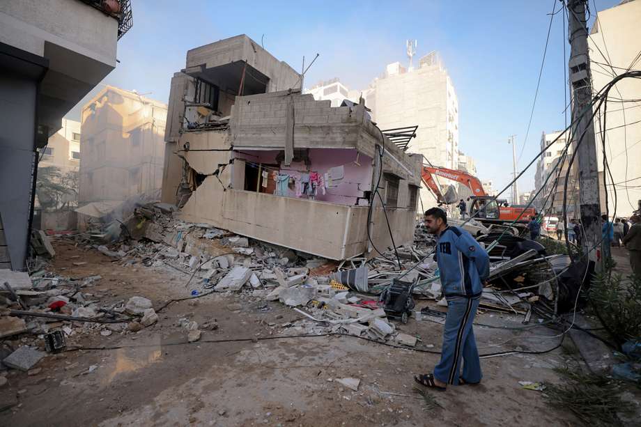 Un palestino pasa frente a un edificio destruido en un barrio residencial de la ciudad de Gaza luego del bombardeo masivo israelí del enclave controlado por Hamas.