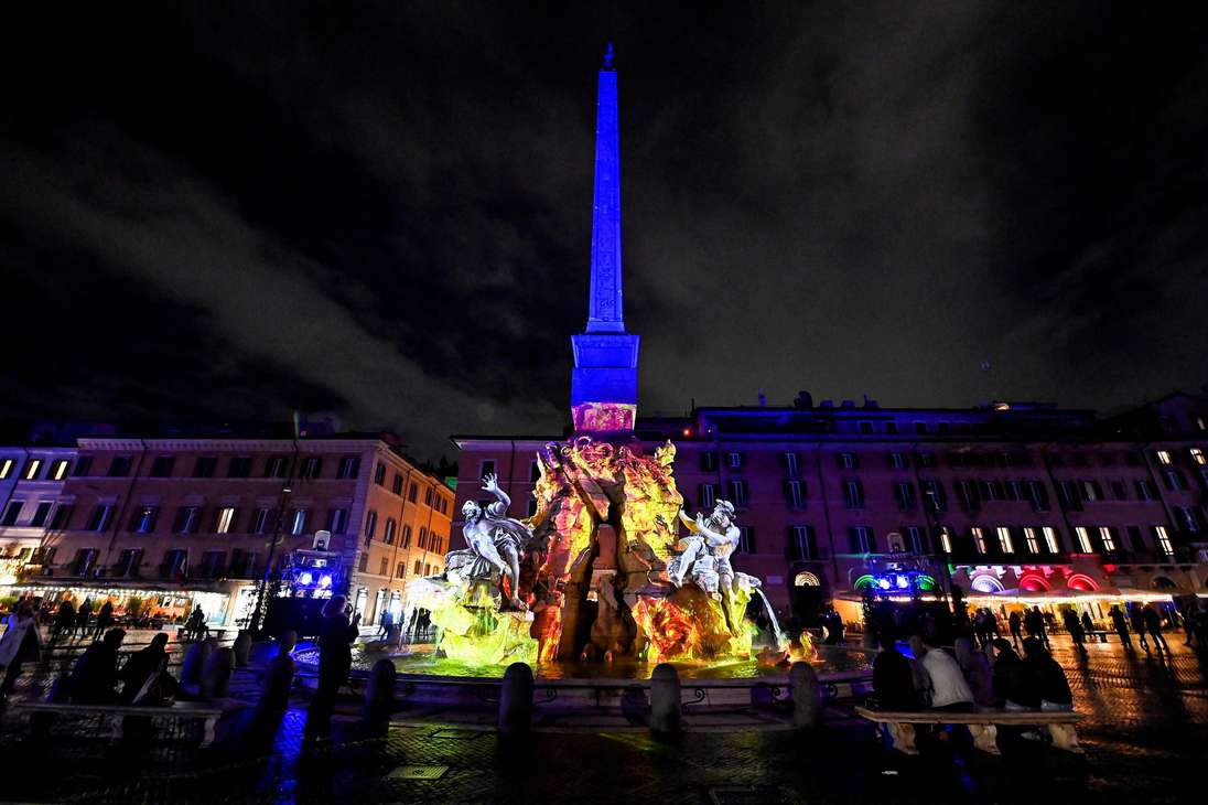 Las tres fuentes históricas en piazza Navona iluminadas con espectáculos de luces en Roma, Italia.