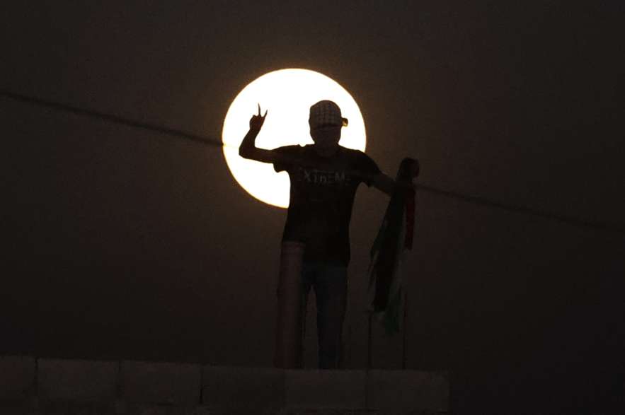 Un ciudadano detrás de la luna llena desde Palestina.