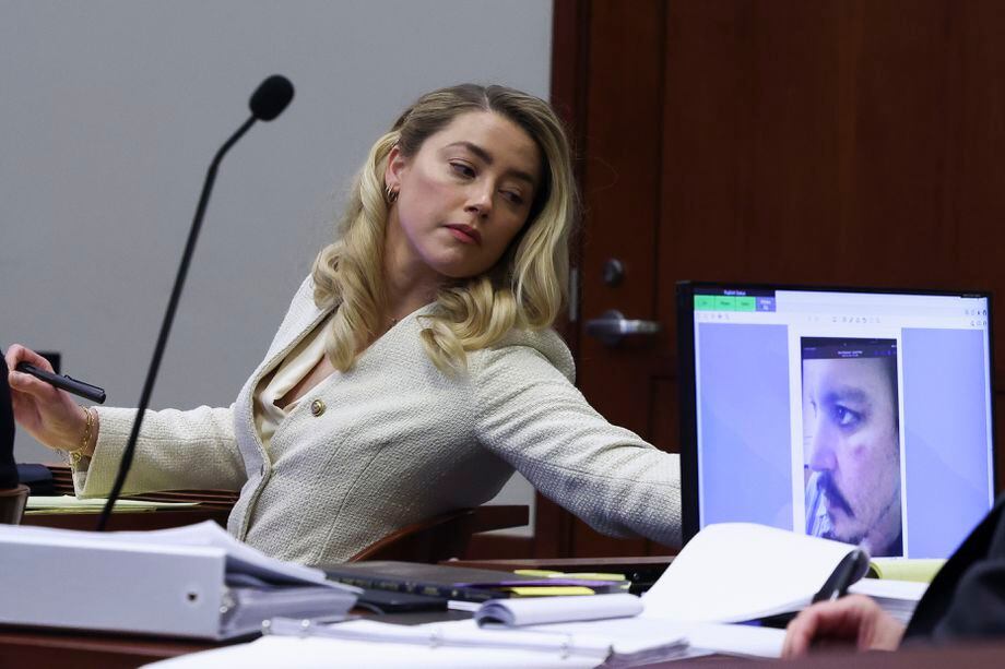 Fairfax (United States), 20/04/2022.- Actress Amber Heard attends her ex-husband Johnny Depp's defamation trial against her, as a picture of an injury to his face is seen on a screen, at the Fairfax County Circuit Courthouse in Fairfax, Virginia, USA, 20 April 2022. Johnny Depp's 50 million US dollars defamation lawsuit against Amber Heard that started on 10 April is expected to last five or six weeks. (Estados Unidos) EFE/EPA/EVELYN HOCKSTEIN / POOL
