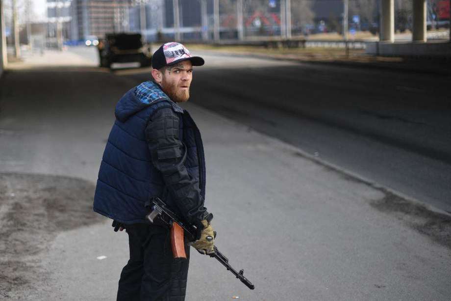 Un voluntario, con un rifle, protege una carretera principal que conduce a Kiev el 25 de febrero de 2022.