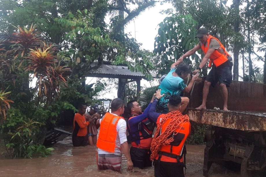 Una foto proporcionada por la Guardia Costera de Filipinas (PCG) muestra al personal de la guardia costera ayudando a un residente durante una operación de rescate en la ciudad afectada por las inundaciones de Plaridel, provincia de Misamis Occidental, Filipinas, 26 de diciembre de 2022.