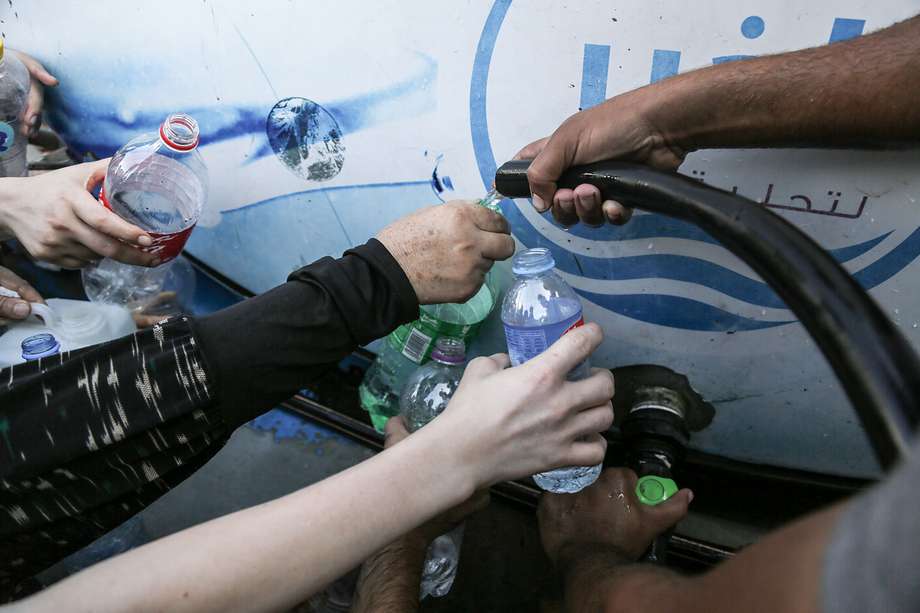 Residentes de Gaza llenan contenedores con agua en la ciudad de Gaza, EFE/EPA/HAITHAM IMAD
