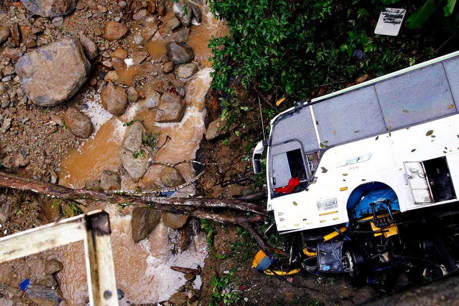 Picture of the wreckage of a bus taken after it plunged down the road connecting Medellin and Bogota, near San Luis, on December 27, 2021. - Seven people, including a pregnant woman, died and 20 were injured when a bus plunged into a ravine in Antioquia Province. (Photo by Fredy BUILES / AFP)