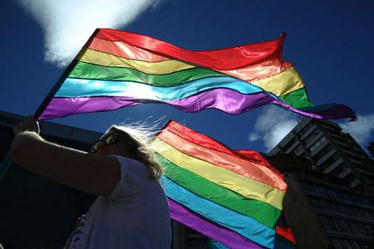 Mujer agita bandera con los colores LGBTI