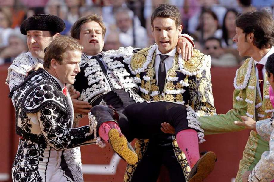 El diestro Julián López "El Juli" es cogido por el primer toro de su lote, del hierro de Cortes, durante la undécima corrida de abono de la Feria de Abril celebrada en la Real Maestranza de Sevilla. / EFE