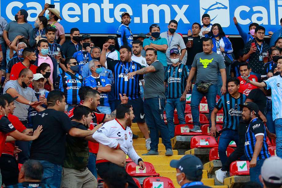 Aficionados de Querétaro y Atlas se enfrentan durante un juego correspondiente a la jornada 9 del Torneo Clausura 2022 de la Liga MX del fútbol mexicano en el estadio Corregidora de la ciudad de Querétaro (México). EFE/Enrique Contla
