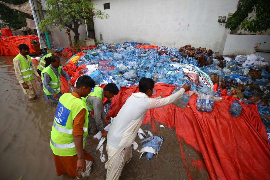 Voluntarios protegen las raciones para ser distribuidas en las zonas afectadas por inundaciones masivas que han afectado a Pakistán desde mediados de junio de 2022. EFE/EPA/SHAHZAIB AKBER
