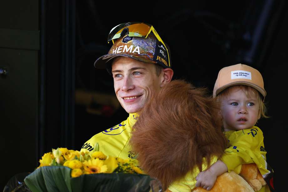 Jonas Vingegaard en el podio del Tour de Francia con la camiseta amarilla y su hija en sus brazos. 