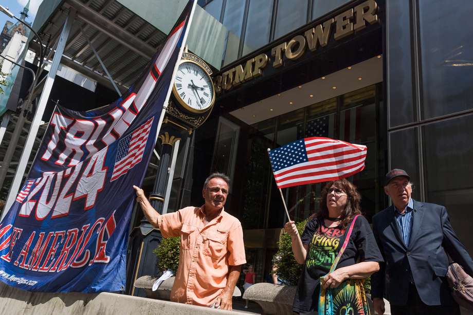 Partidarios del expresidente estadounidense Donald Trump sostienen una pancarta frente a la Torre Trump en Nueva York.
