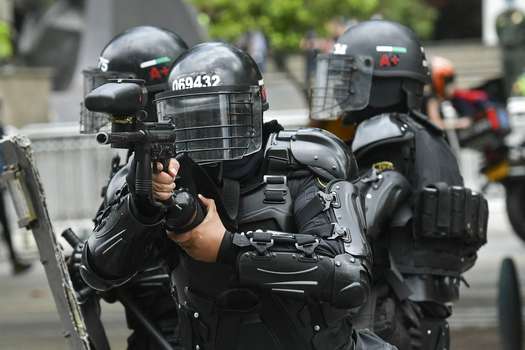 Policías antidisturbios apuntan a manifestantes durante una protesta contra la reforma tributaria, en Bogotá. 