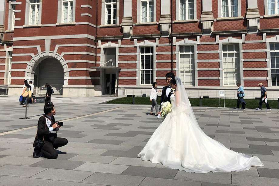 Recién casados al estilo occidental, en sesión fotográfica frente a la estación central de Tokio. 