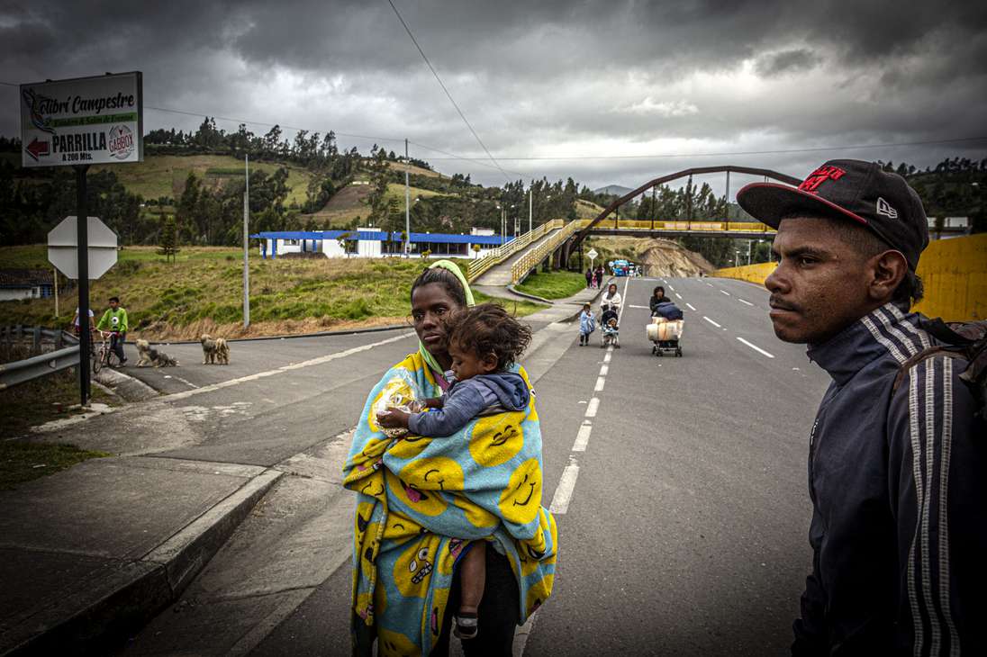 Yucleisy Rondón sostiene a su hijo mientras ingresa a Colombia por el Puente Rumichaca, entre Ecuador y Colombia.