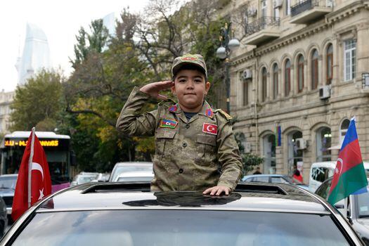 Un niño vestido con el uniforme militar de Azerbaiyán participa en marchas para celebrar el fin de los enfrentamientos con Armenia por Nagorno Karabaj.