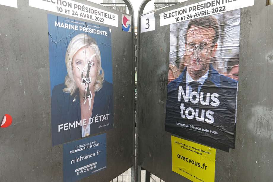 Dos carteles electorales de Emmanuel Macron y Marine Le Pen se "enfrentaron" en las calles de París durante la primera vuelta presidencial. 