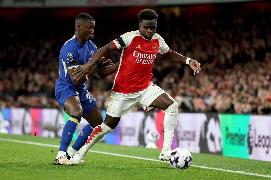 Bukayo Saka (der), del Arsenal, disputa un balón con Moisés Caicedo, del Chelsea.