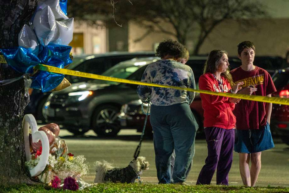 Un grupo de personas habla cerca de un monumento a las víctimas de un tiroteo masivo en el Walmart Supercenter en Chesapeake, Virginia.
