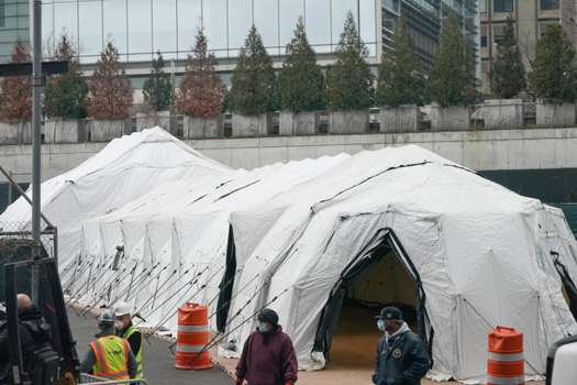 Los trabajadores construyen una morgue improvisada en las afueras del Hospital Bellevue para manejar un aumento esperado en las víctimas de coronavirus en Nueva York. / AFP