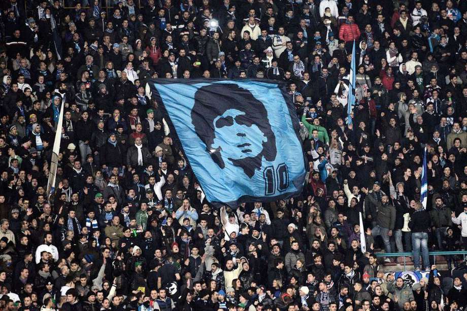 Una bandera de Diego Maradona en medio de la afición de Nápoles.