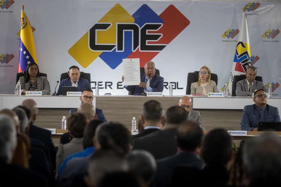 Elvis Amoroso (c), presidente del Consejo Nacional Electoral (CNE), muestra la lista oficial con los candidatos a elecciones presidenciales, este lunes en Caracas.