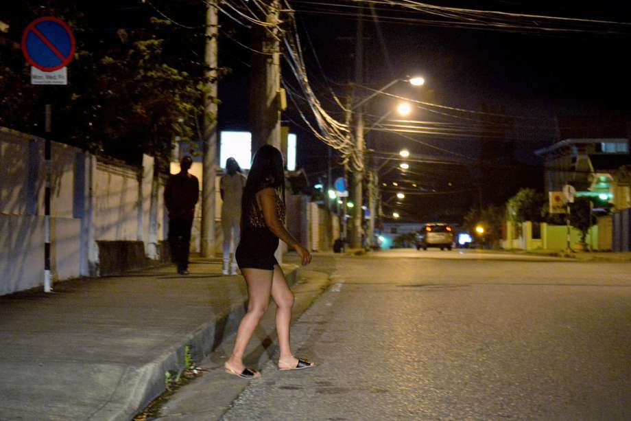 Una migrante cruza la calle de St James, Puerto España. Muchas venezolanas han llegado a Trinidad y Tobago captadas por redes de prostitución.  / Robert Taylor / AFP